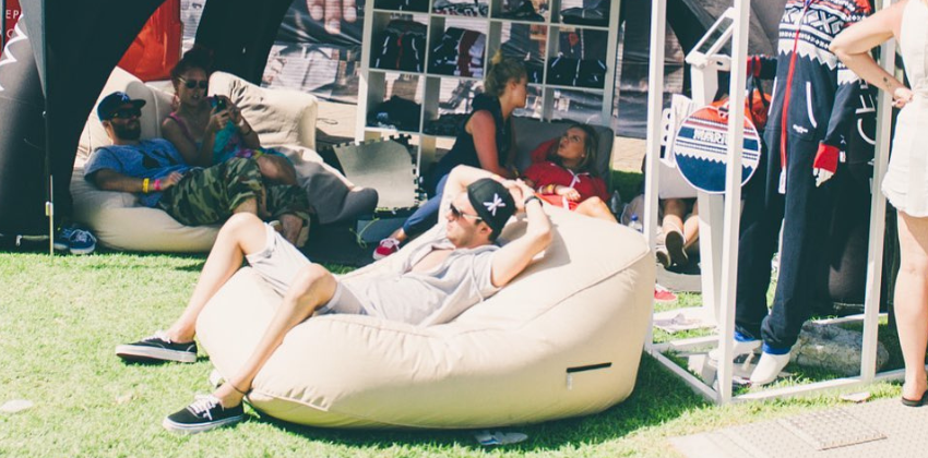 man sitting on an Ambient lounge outdoor satellite twin sofa