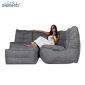 Woman lounging on a Mod4 corner deluxe titanium weave lounge set from ambient lounge in new zealand