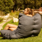 Woman sitting outdoor on a titanium weave acoustic sofa bean bag from Ambient lounge in New Zealand